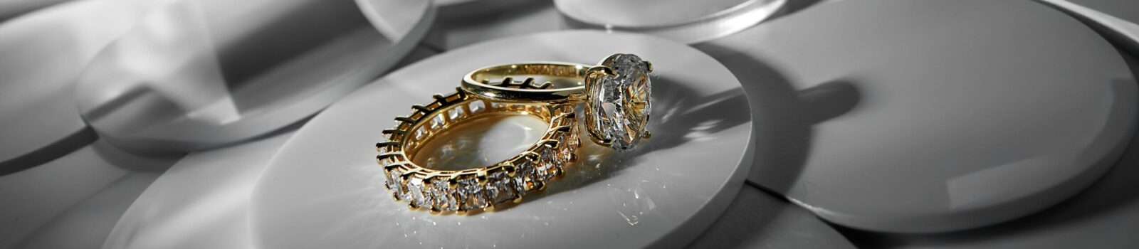 pexels-photo-30541185-30541185 Close-up of elegant gold and diamond rings on a modern abstract surface, showcasing luxury style.